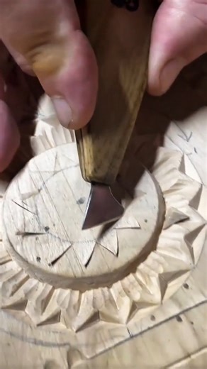 Carving geometric floral pattern into wooden surface using chisel