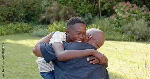 African American dad, teen reuniting, jumping into father's arms, kissing cheek, watch worn in yard