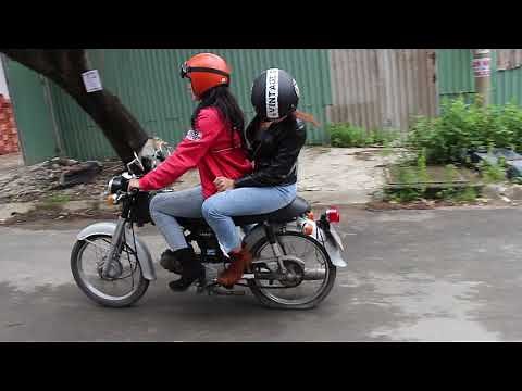 TWo girls on old moped with flat tire