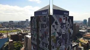 1.7K views · 88 reactions | Hollard and Russell Abrahams have collaborated to create one of SA’s largest artworks for the Life Centre building in downtown Jozi. Conceptualised during the COVID-19 pandemic, the artwork captures some of the realities of these uncertain times, alongside those things that make Mzansi unique. We like to think if it partnering for the win-win-win: Hollard and Russell benefit from the association and Jozi gets a big, beautiful beacon of hope. | Hollard | Facebook