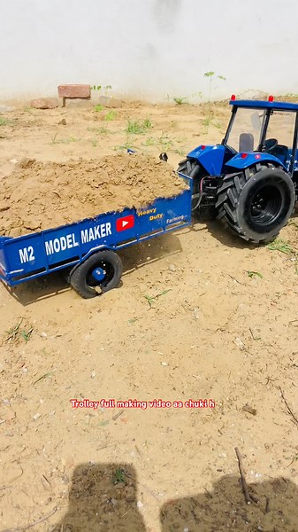 Rc Newholland tractor pulling loaded trolley for soil work