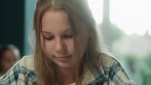 Girl teenager Caucasian kid child daughter schoolgirl pupil concentrated student study school library learning writing homework at classroom prepare exam notes task copybook primary education studying