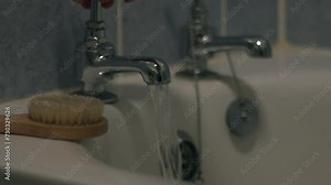 Woman turning on bath taps