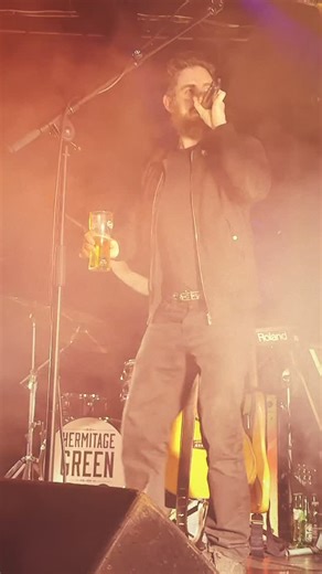 Hermitage Green on Instagram: "This is @bobby__fingers. Bobby Fingers doesn’t exist. He is a figment of the Limerick collective conscience. But everyone in Limerick knows that if you look in a mirror and say “Bobby Fingers” three times he will appear. On NYE we were playing Dolans Warehouse and decided to conjure him up for the craic. He appeared and he used very bad language and he was drinking a pint of Carlsberg onstage and he asked our audience if they’ve ever gotten child’s shit under their
