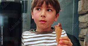 Child eating cone ice-cream as dessert