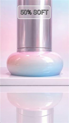 A glossy translucent pastel sphere placed under a hydraulic press