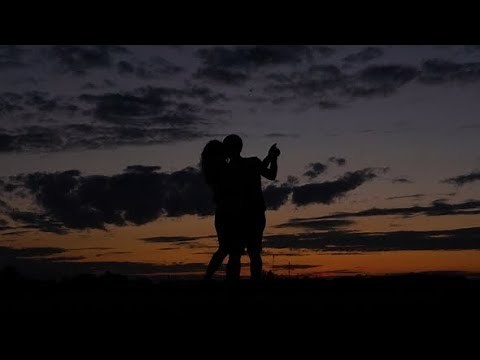 Dark Silhouette of Romantic Couple Dance and Swirl in a Scarlet Sunset | Stock Footage - Videohive