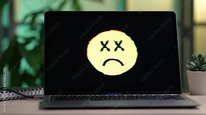 Laptop Computer Screen With a Sad Face Emoji on Display