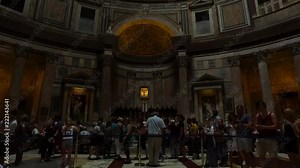 A view from the inside of the Pantheon. Shot with near perfect symetry, we see the tourists and our view rises up to the top of the building, where the summer light is coming in