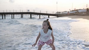 Little girl playing on the beach in summer