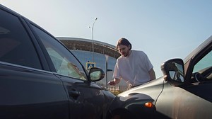 Person responsible for the accident, seeing the consequences, holds his head in his hands and expresses regret. Mid shot. Slow motion