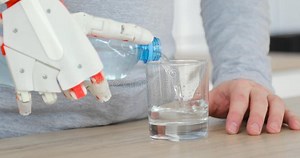 Man with Robotic Prosthetic Hand is Pouring Water in Glass from the Bottle and Drinking it in the Kitchen. Stock Video - Video of kitchen, fiction: 144688821