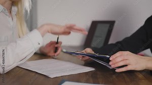 A client in the office signs a document with a pen. Signing of the lease agreement at the notary. Only hands in the frame