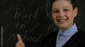 Back to school. Online learning, distance learning, student technology, business conference. Joyful little boy dancing near the school board. Emotions. 4K