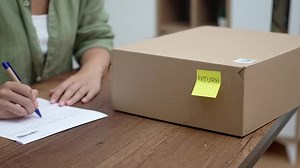 Lady at Home Completes a Return Order Form Articulating Her Intention to Return a Purchased Item