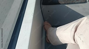 Cross legs girl is shaking one leg over the other. Woman in a train or tram. Day time. Transport concept. Relax concept. Plain Life.