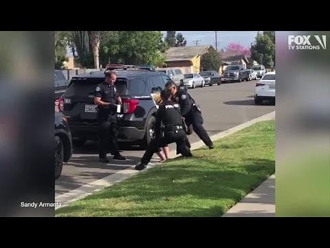 Police officers stop fellow officer punching handcuffed woman during arrest