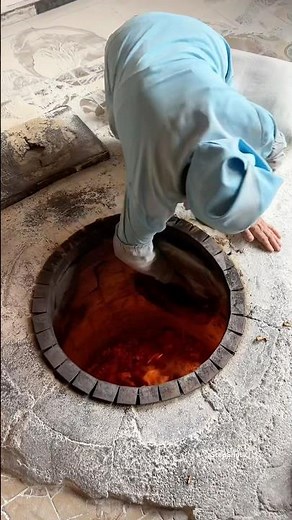 Baking Armenian traditional Lavash bread in old tonir oven