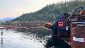 Log hoist moving logs out of the water for further processing at sawmill"