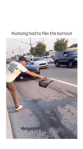 Wise Brain Hub on Instagram: "The video depicts a man watering a road for a typical burnout smoke effect, but a black Ford Mustang then executes a massive dry tire burnout, humorously “flexing” its superior power by producing thick smoke without water, a nod to high-performance car culture. - Posted today by @LambeRandom, an Indonesian creator focused on random global curiosities, the clip has exploded to 899,000 views, 555 likes, and 120 replies, showcasing viral appeal in automotive enthusiast