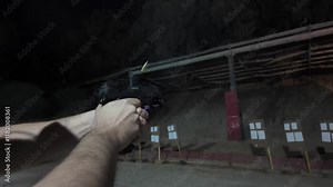 Slow-motion footage of a person shooting a handgun at a shooting range, capturing the precise moment of the gunshot with dramatic detail. Perfect for concepts of sports shooting, firearm safety, and c