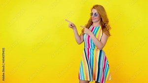 Woman and pointing at mockup workspace for advert, marketing, promotion or text. Fashionable model showing mock up for advertising, news deal of offer, trendy makeup, outfit, studio yellow background