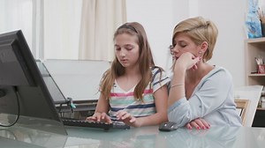 Mom helps daughter with distance learning on PC - Free Stock Video