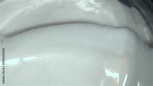 Foam in the washing machine. Washing clothes in the washing machine. Lots of foam in the washing drum.