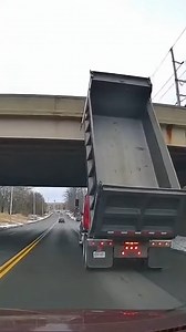 Dump Truck Hits Bridge in Dramatic Crash Indianapolis, Indiana — October 14, 2025 A dramatic highway accident was captured on a dashboard camera Monday afternoon when a dump truck traveling with its bed fully raised slammed into an overpass. The impact sent shockwaves through the vehicle and left the massive steel container mangled against the concrete structure. The footage shows the red truck traveling at highway speeds as it approaches the low-clearance bridge. The driver, seemingly oblivious