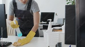 Slowmo tilt up of young female cleaning service worker wiping desk in modern office using detergent and cloth Stock Video
