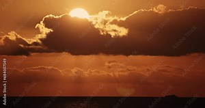4K sunset dusk twilight sundown timelapse clouds sky. Epic motion of golden rays breaking through dramatic dark cloudscape in a vivid and serene evening