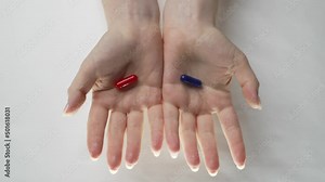 Red or blue tablet. The problem of choice. There are red and blue pills in women's hands. Blue and red pills are poured from above into the hands.