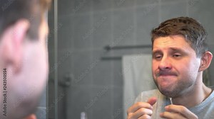 A young man pulls out his nose with tweezers.
