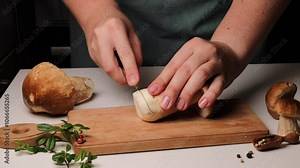 Female chef slicing boletus mushroom into pieces. delicious porcini mushroom recipe. Step-by-step process of preparing gourmet mushroom dish.Sliced boletus mushroom by female chef’s hands.