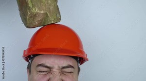 Safety helmet. Brick and a board fall on builder head. Saving a life due to wearing a protective construction helmet. Protection of worker from accidents. Falling objects from a height. Slow mo effect