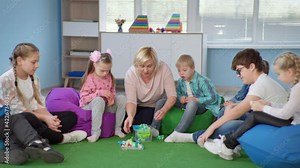 female teacher conducts educational trainings in an inclusive classroom with children with down syndrome during lesson at school
