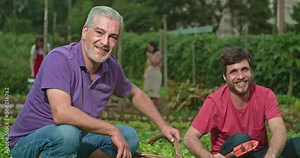 Small rural community farm with people cultivating soil and organic food