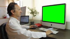 Man In His Home Office Typing On A Keyboard, Green Screen Computer Display