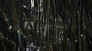 Black plastic wrap or polyethylene bag. Crumpled vinyl. Ecological problems. Recycling of recyclable materials. Packaging for goods. Dark stretch film. Polyvinylchloride. Background copy space texture