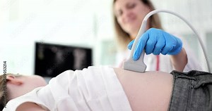 Doctor pediatrician conducting abdominal ultrasound examination of internal organs of child in clinic 4k movie slow motion. Diagnosis of treatment of diseases of gastrointestinal tract in children