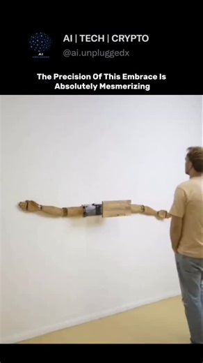AI | TECH | CRYPTO on Instagram: "The video features a fascinating 14-second satisfying clip where a man interacts with a mechanical art installation-and the machine's response is nothing like what people expect. As he approaches the wall and leans in, the footage shows two wooden mechanical arms extending and wrapping around him in a perfect, gentle embrace. Proving how art and engineering can evoke human emotion, this "hugging machine" uses a series of gears and sliding joints to mimic the nat
