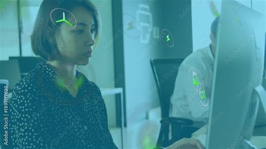 Woman typing at desktop in office and generating floating environmental icons showing carbon data