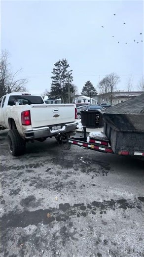 Lmm duramax lifted truck hooked up to dump trailer loaded with brush material