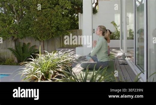 Two women shifting from prayer into mudra seeking stillness on poolside meditation mats, copy space. Wellness, serenity, mindfulness, relaxation, harmony, outdoor, contemporary Stock Video Footage - Alamy
