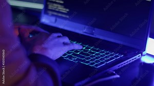 The hacker is typing fast on the keyboard due to the approach of the police