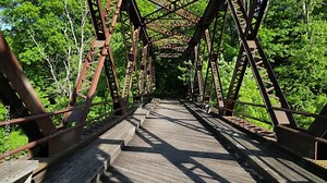 Springtown Railway Bridge over River in Springtown, New York Wallkill Valley Rail Trail (Paltz trestle viaduct) aerial drone view steel beams bars wooden platform from above trees scenic bike trail