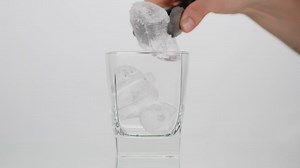 Person fills a glass with cola on white background - Free Stock Video