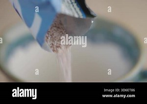Pouring instant coffee powder into a cup .