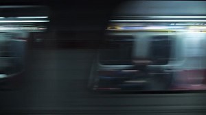 Looking out the window of the subway while another subway zooms