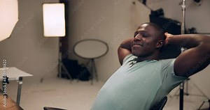 Black man, producer and relax with completion, done or finished with tasks, project or deadline at studio. Young African, male person or photographer leaning back with smile for rest or break at set